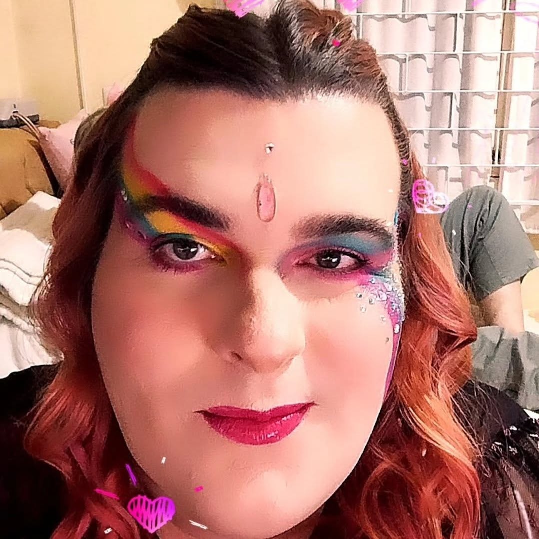 Paloma com maquiagem de arco-íris e brilhos no rosto, sorrindo suavemente